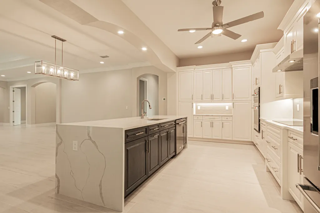 Kitchen island dishwasher at The Heron House, a custom home built by Marvin Homes in Naples, Florida
