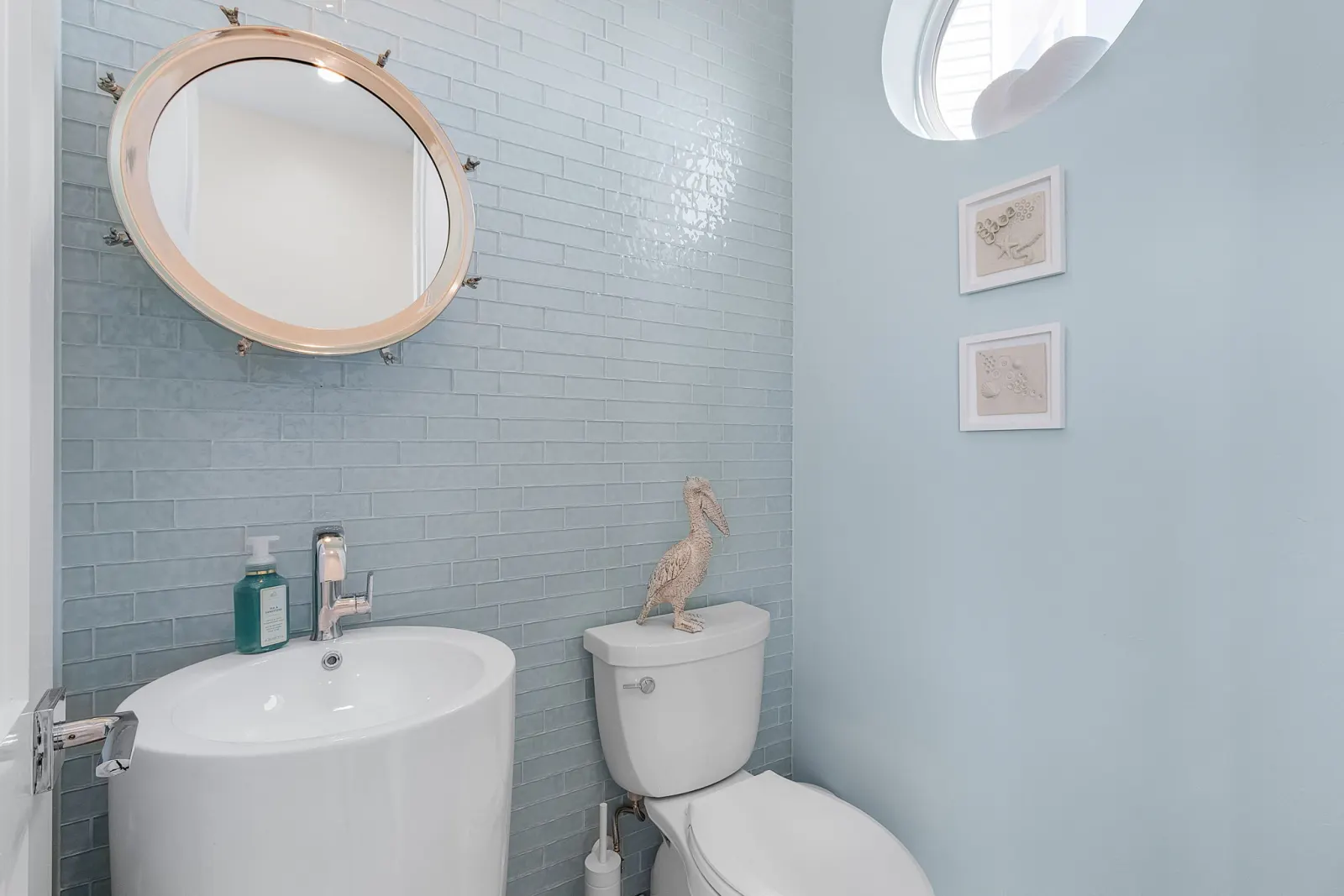 Bathroom powder room pelican decor at Pelican's Perch, a custom home built by Marvin Homes in Cape Coral, Florida