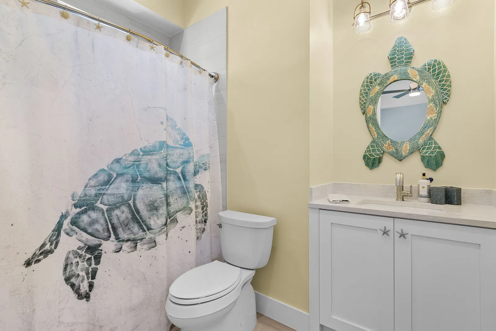 Bathroom turtle mirror shower curtain at Pelican's Perch, a custom home built by Marvin Homes in Cape Coral, Florida