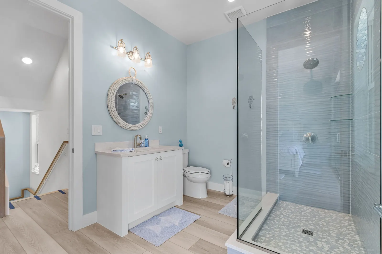 Bathroom wave tile rope mirror at Pelican's Perch, a custom home built by Marvin Homes in Cape Coral, Florida