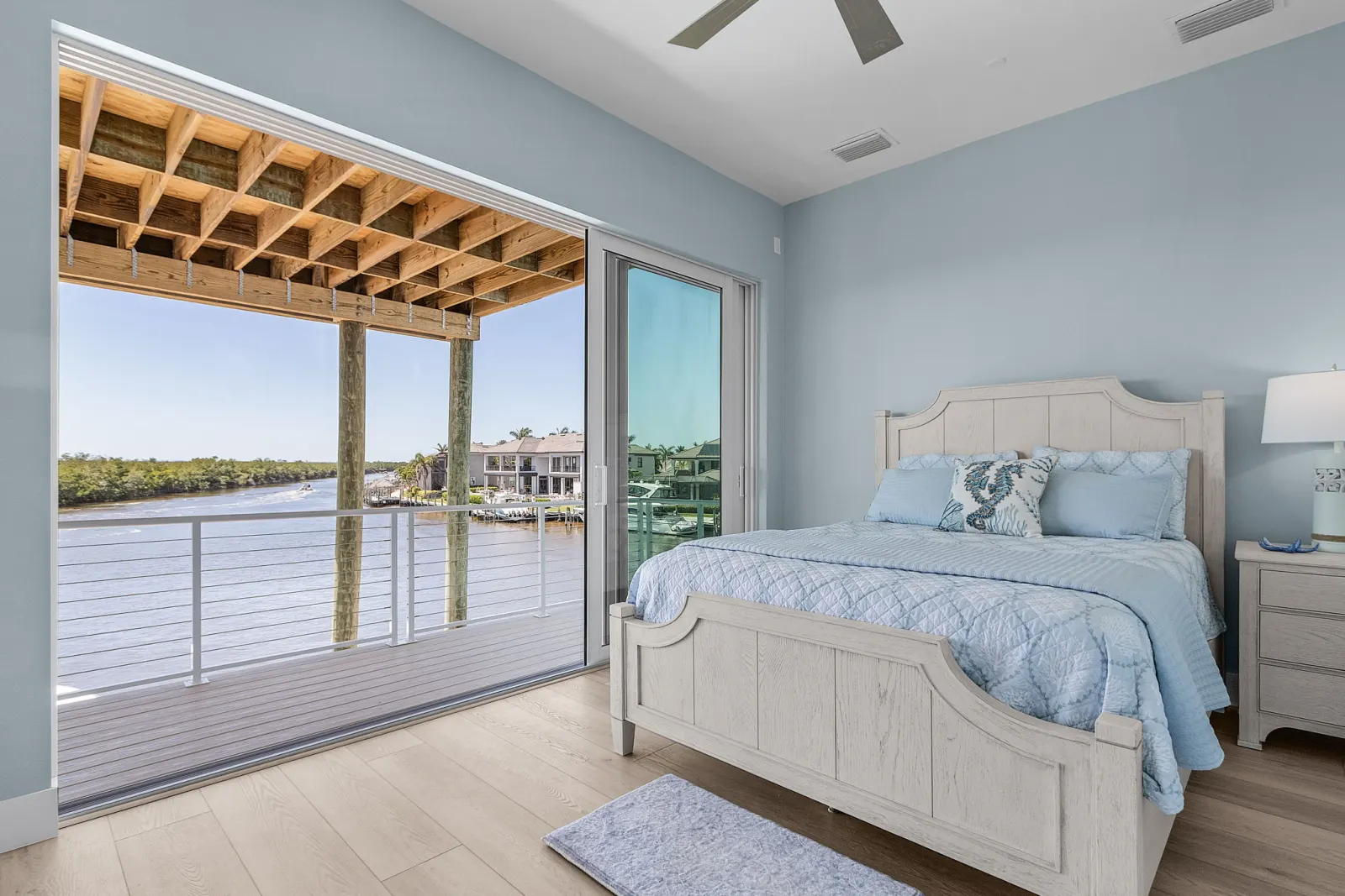 Bedroom blue canal view headboard at Pelican's Perch, a custom home built by Marvin Homes in Cape Coral, Florida