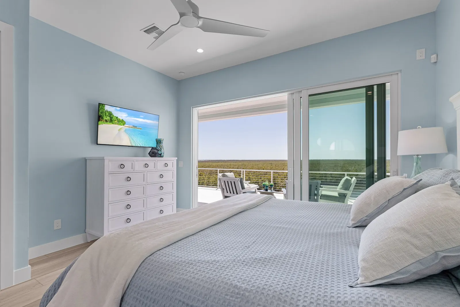 Bedroom tv balcony ocean view at Pelican's Perch, a custom home built by Marvin Homes in Cape Coral, Florida