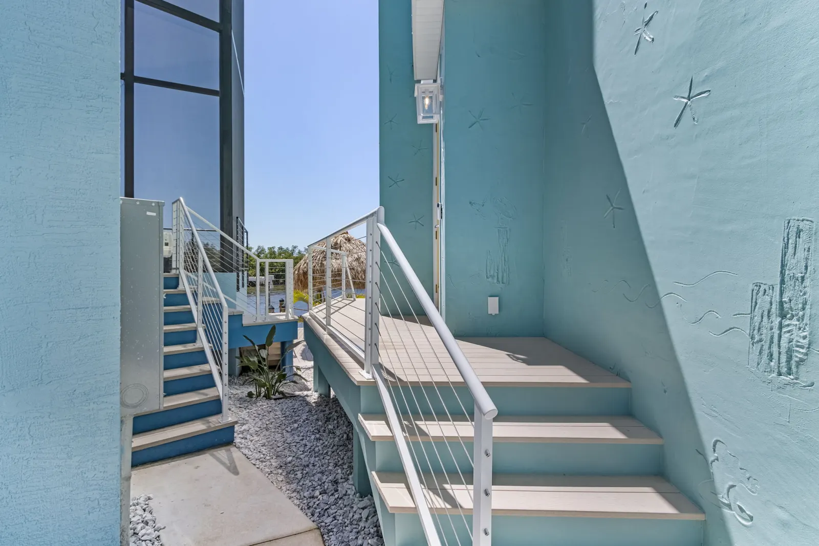 Exterior side stairs starfish wall at Pelican's Perch, a custom home built by Marvin Homes in Cape Coral, Florida