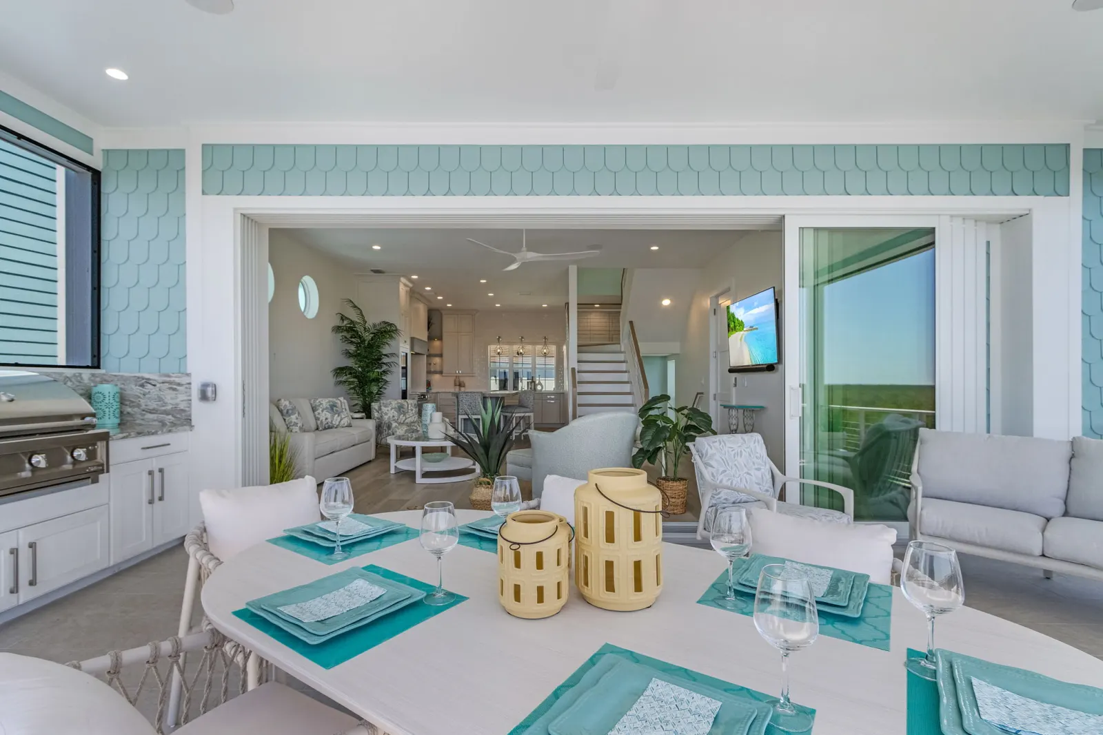 Lanai dining table open to living at Pelican's Perch, a custom home built by Marvin Homes in Cape Coral, Florida