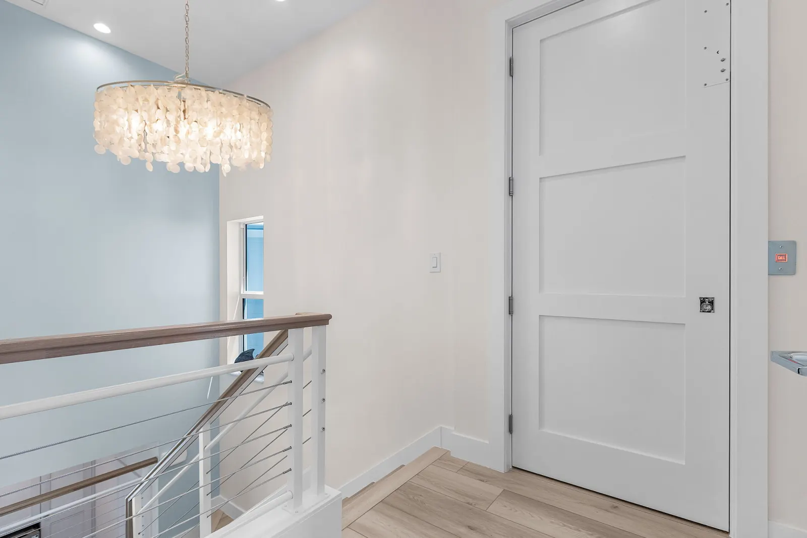 Landing shell chandelier elevator at Pelican's Perch, a custom home built by Marvin Homes in Cape Coral, Florida